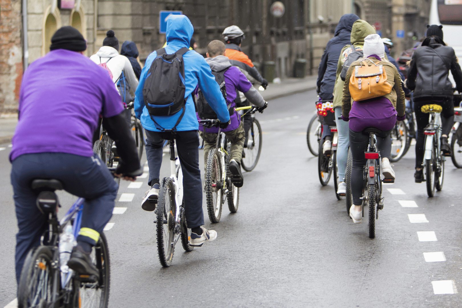 People on bikes riding away in an urban setting