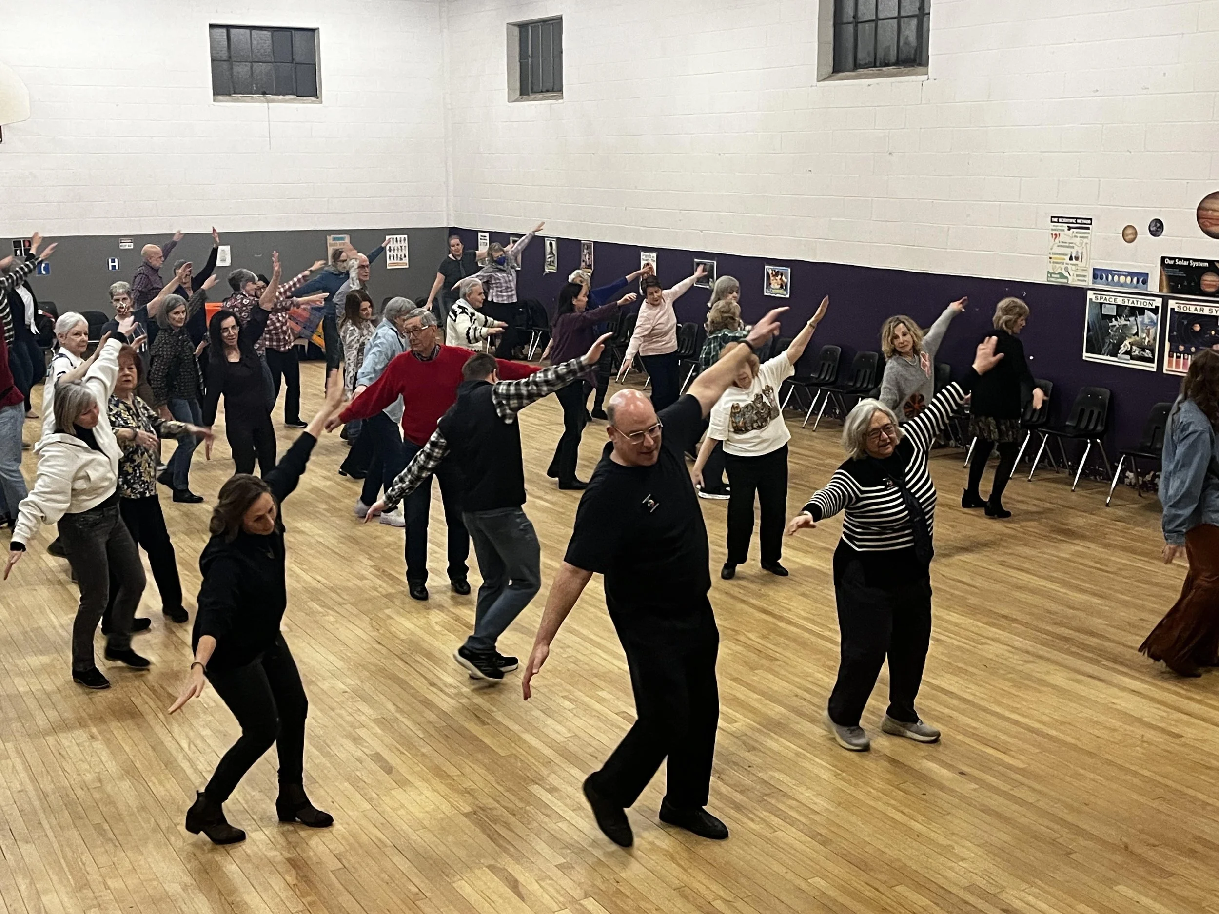 Men and women line dancing in a gym