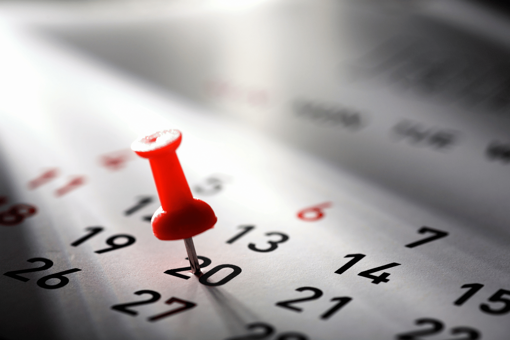 Calendar with red push pin in it