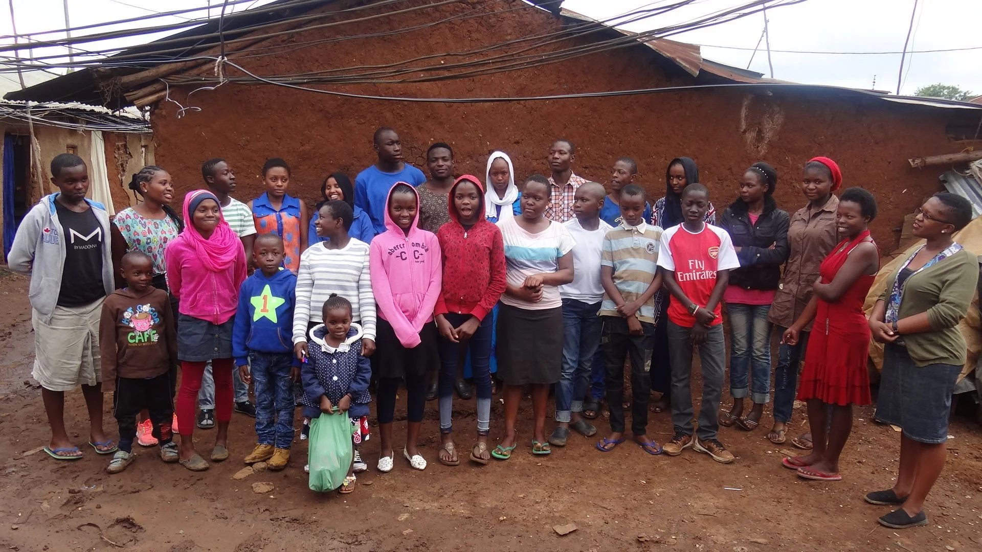 Community group standing in front of building in Kibera