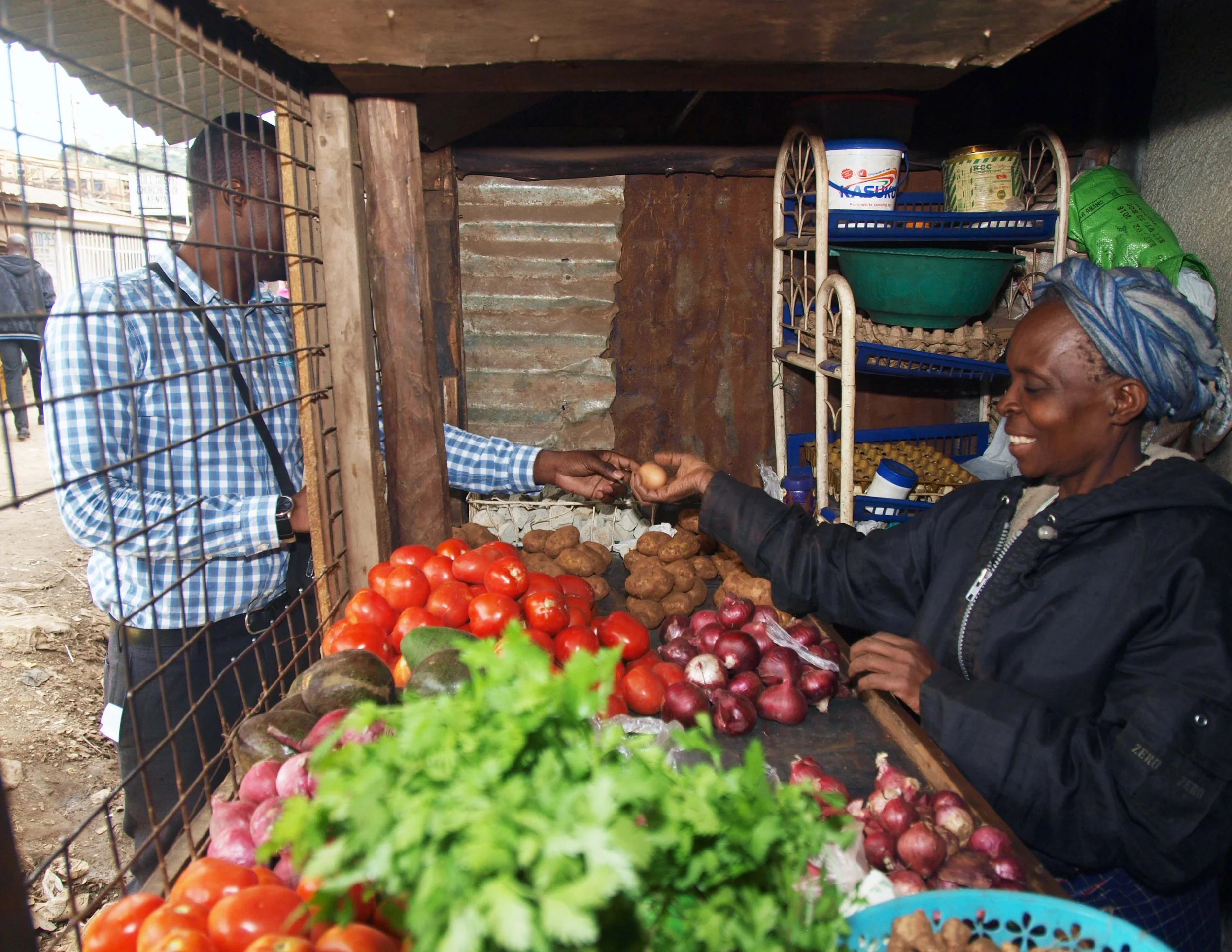 Woman serving a customer eggs from her market stall