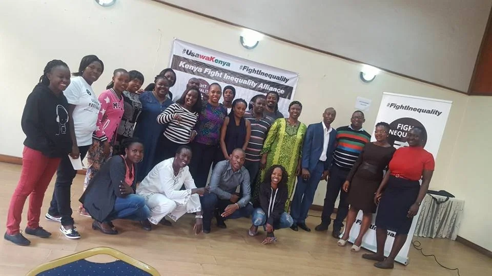 Young people in front of a Fight Inequality banner