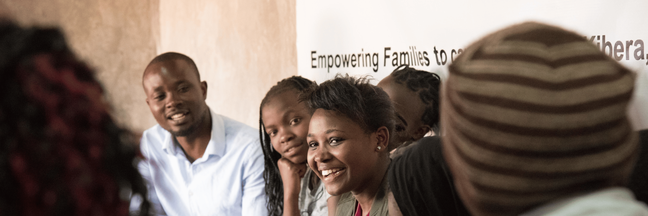Moses and students in front of a banner that reads "Empowering Families..."