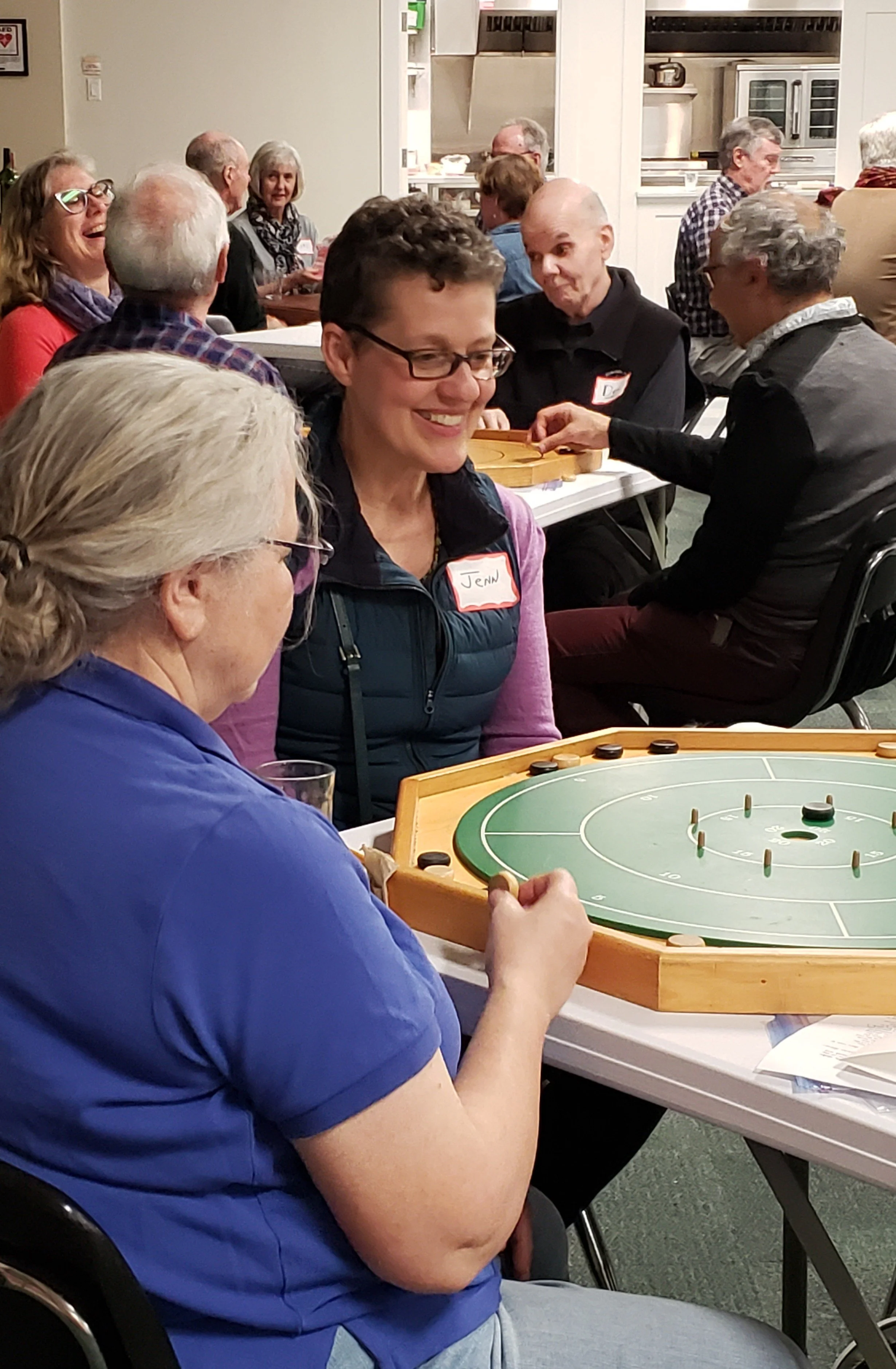 People laughing playing crokinole