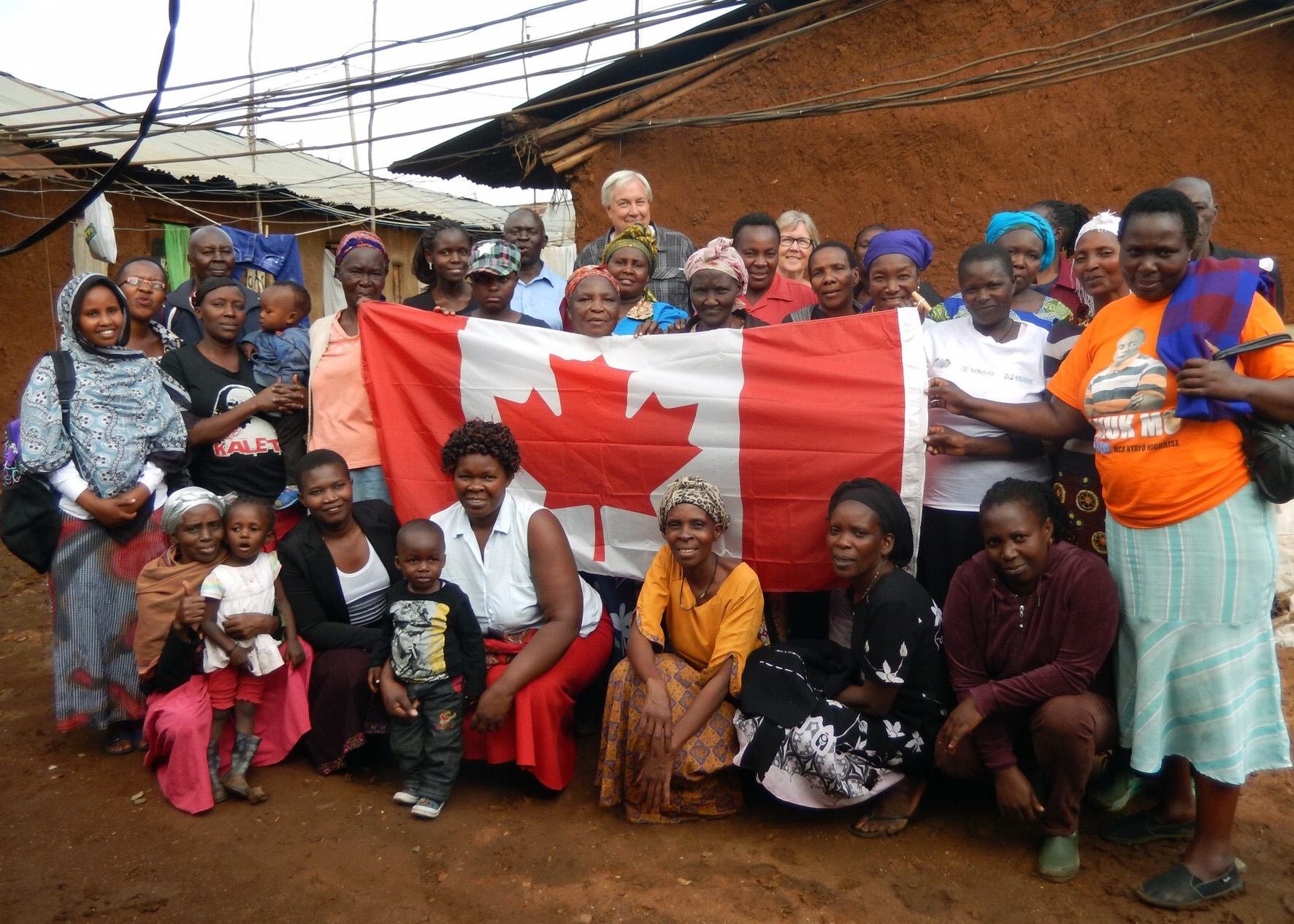People of Kibera and VoLC volunteers in front of Canadian flag