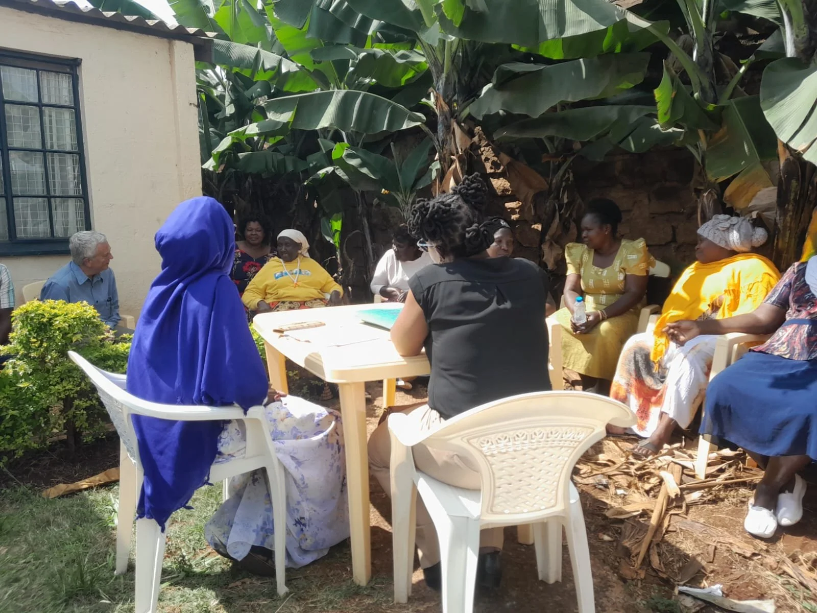 Ian attending a cluster meeting with women outside