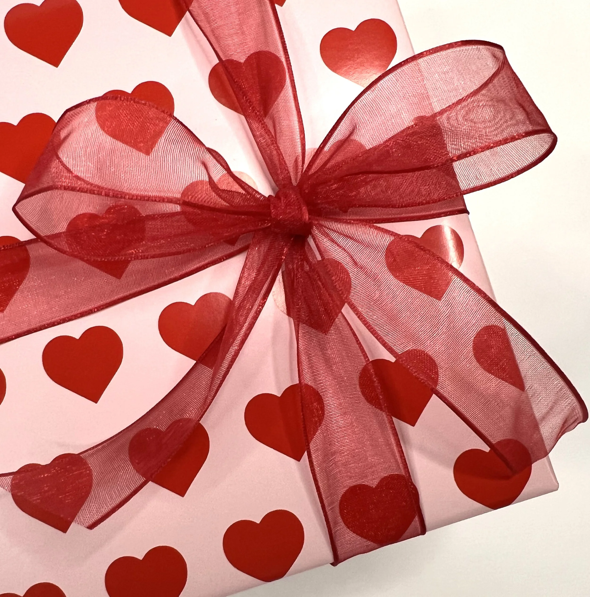 Wrapping Valentine's red hearts red AKD bow.jpeg