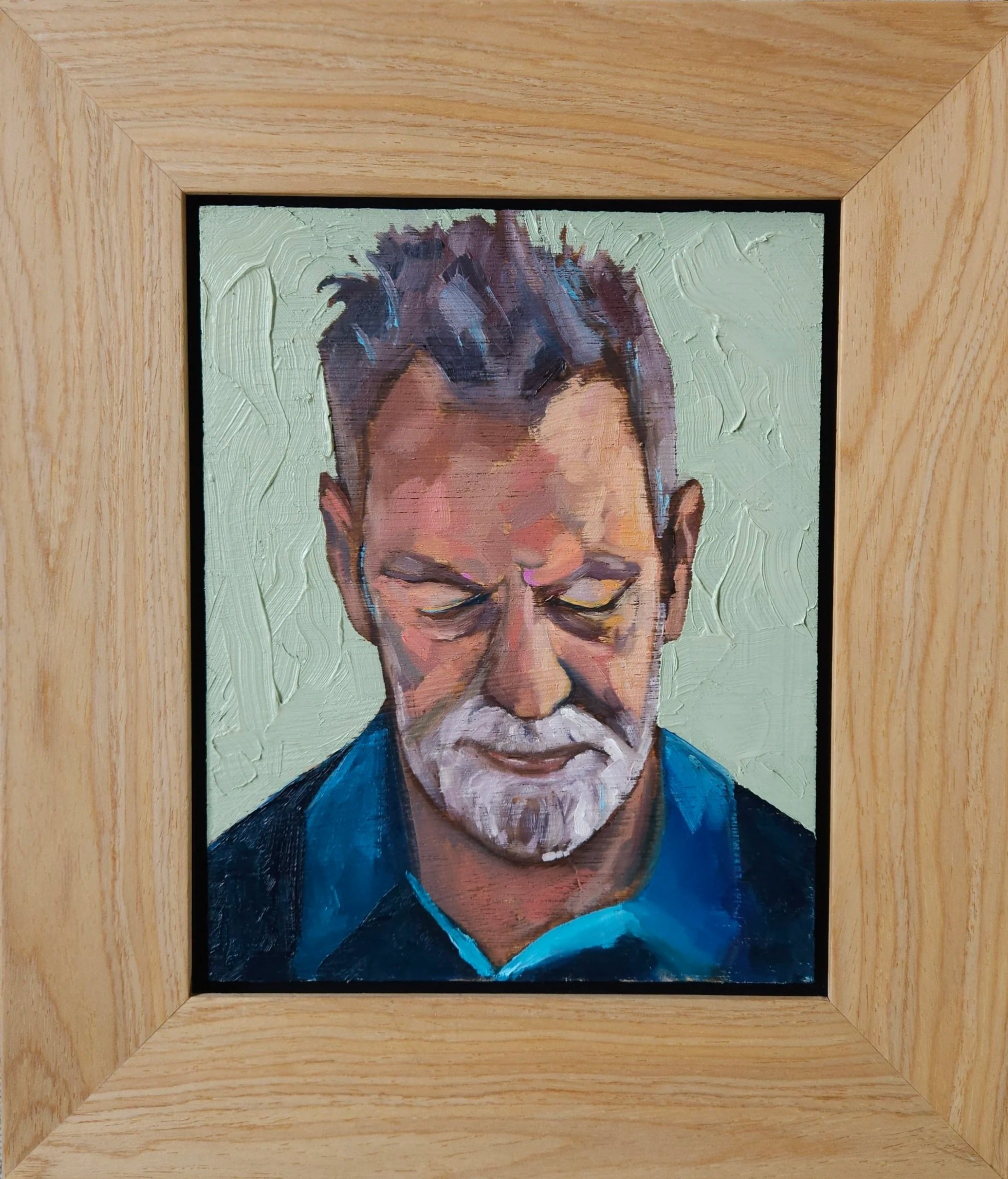 A framed oil painting of an elderly man with white hair and beard, eyes closed, wearing a dark blue shirt, against a light green textured background.