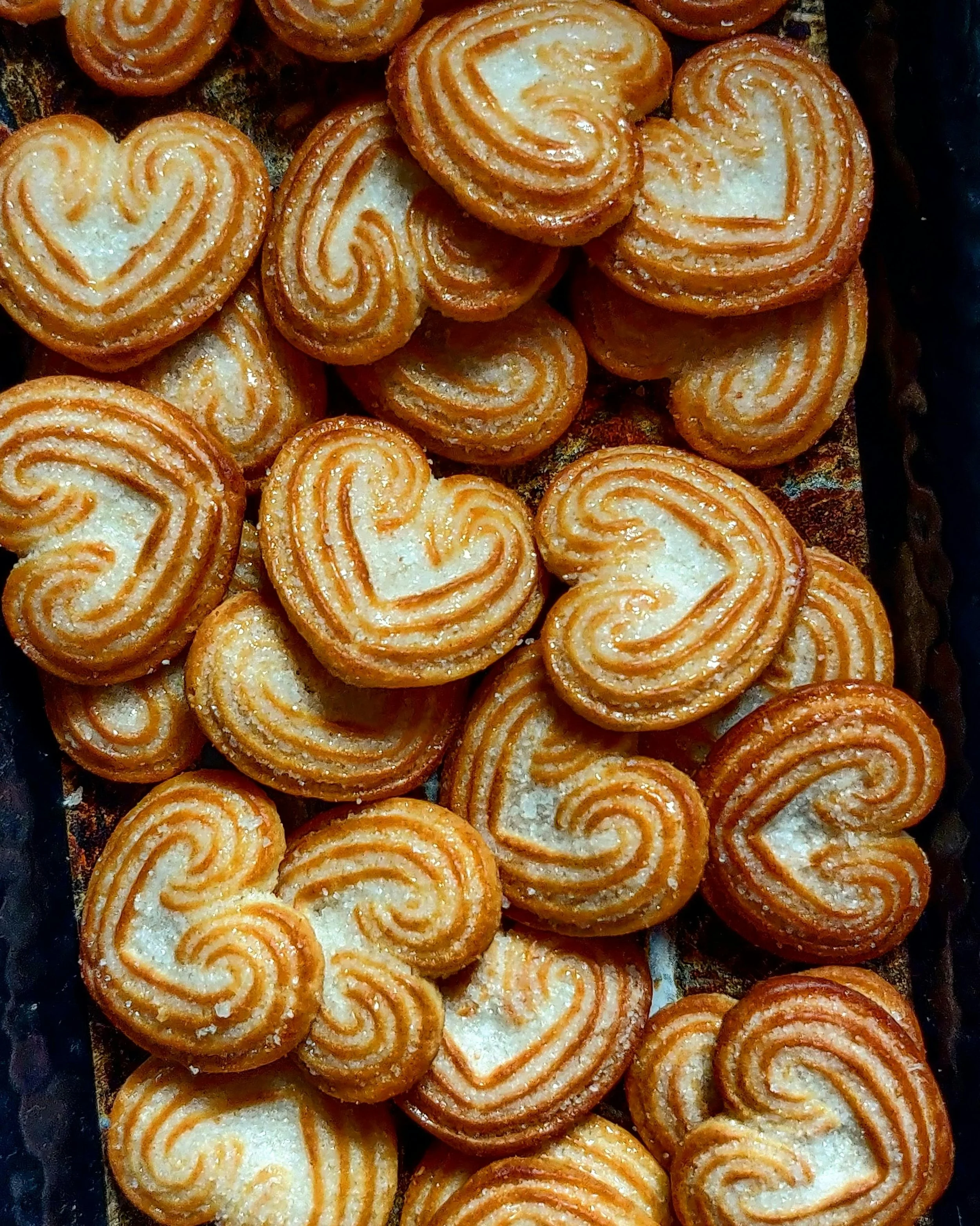 Heart-shaped palmiers cookies with caramelized sugar, arranged in a pile.