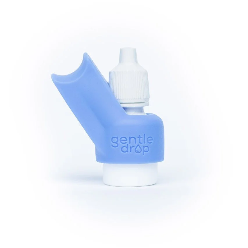 A GentleDrop eyedrop aid with a white eyedrop bottle, against a white background.