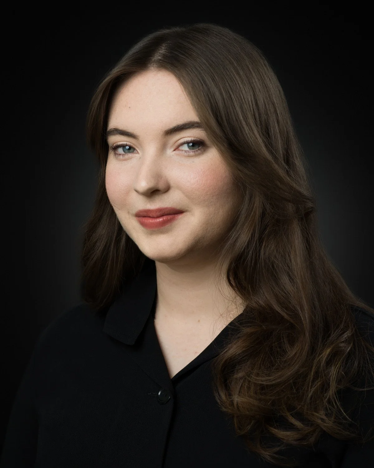 Theatrical headshot of Skyela Jones with a subtle, knowing expression. Her captivating gaze is intelligent and warm, suggesting a grounded, thoughtful presence with a rich internal world and significant social awareness suitable for stage and screen.