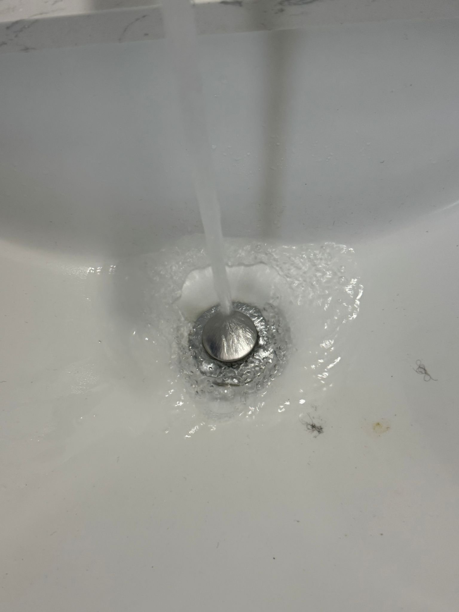 Running bathroom sink water to ensure it is clogg free.
