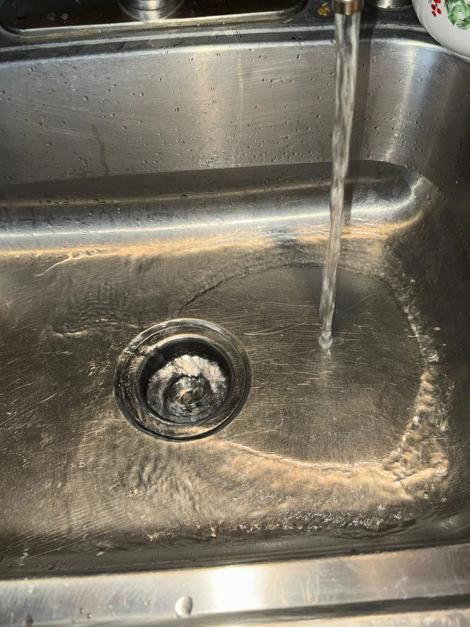 Running water to ensure the kitchen sink is unclogged.