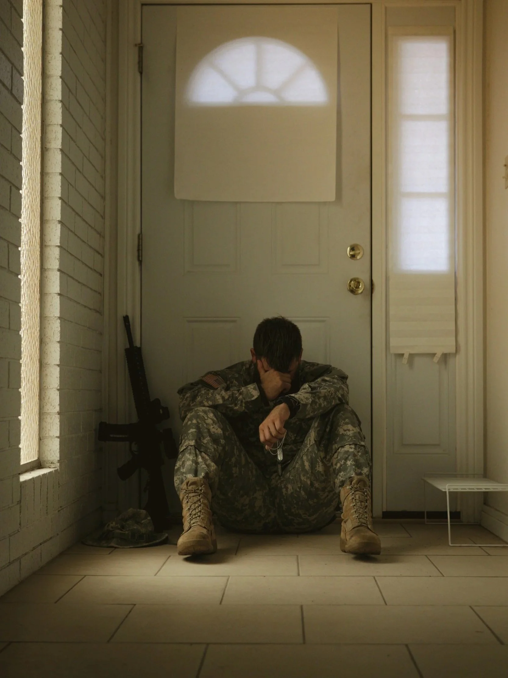 soldier sitting in front of door depressed