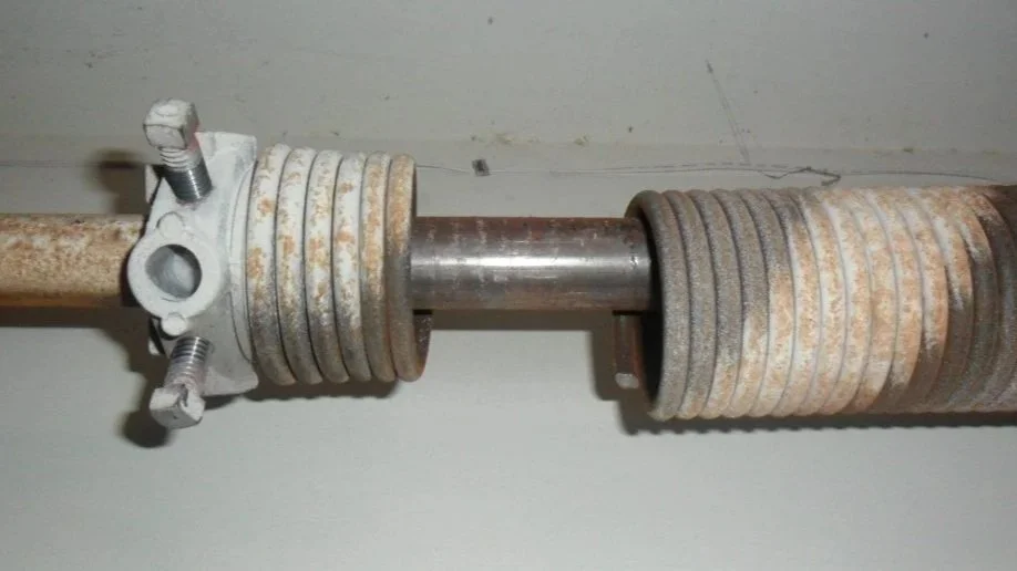 Close-up of a rusty mechanical shaft with layered rings and bolts.