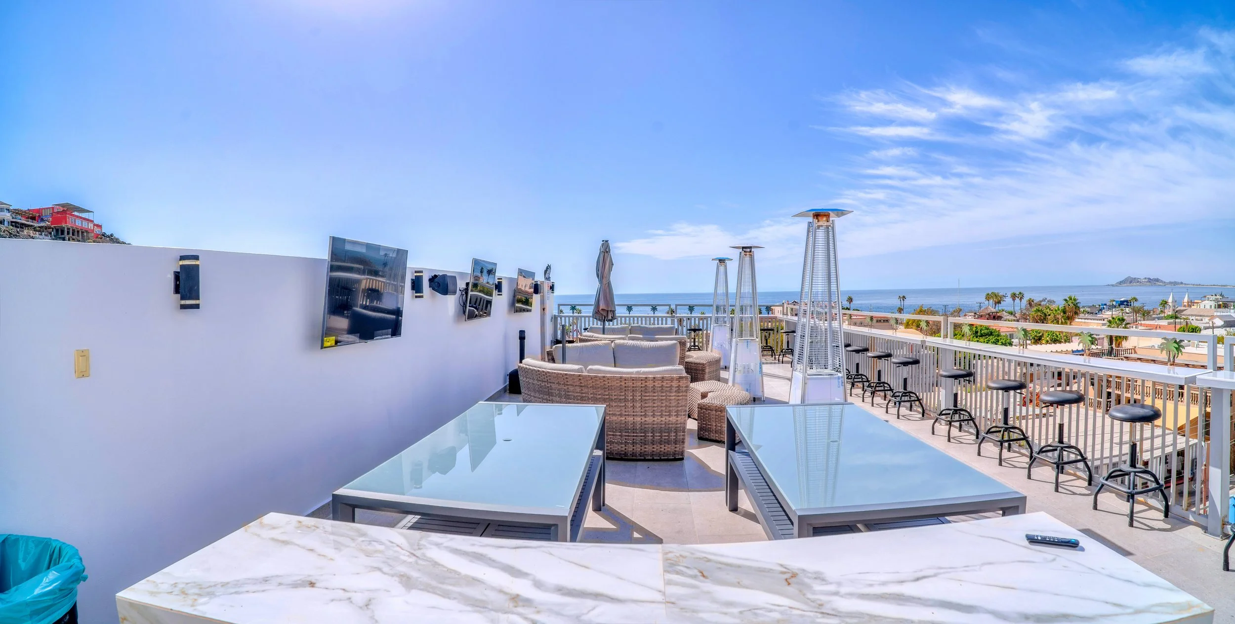 Terraza con sillones y mesas, vista al mar y cielo soleado