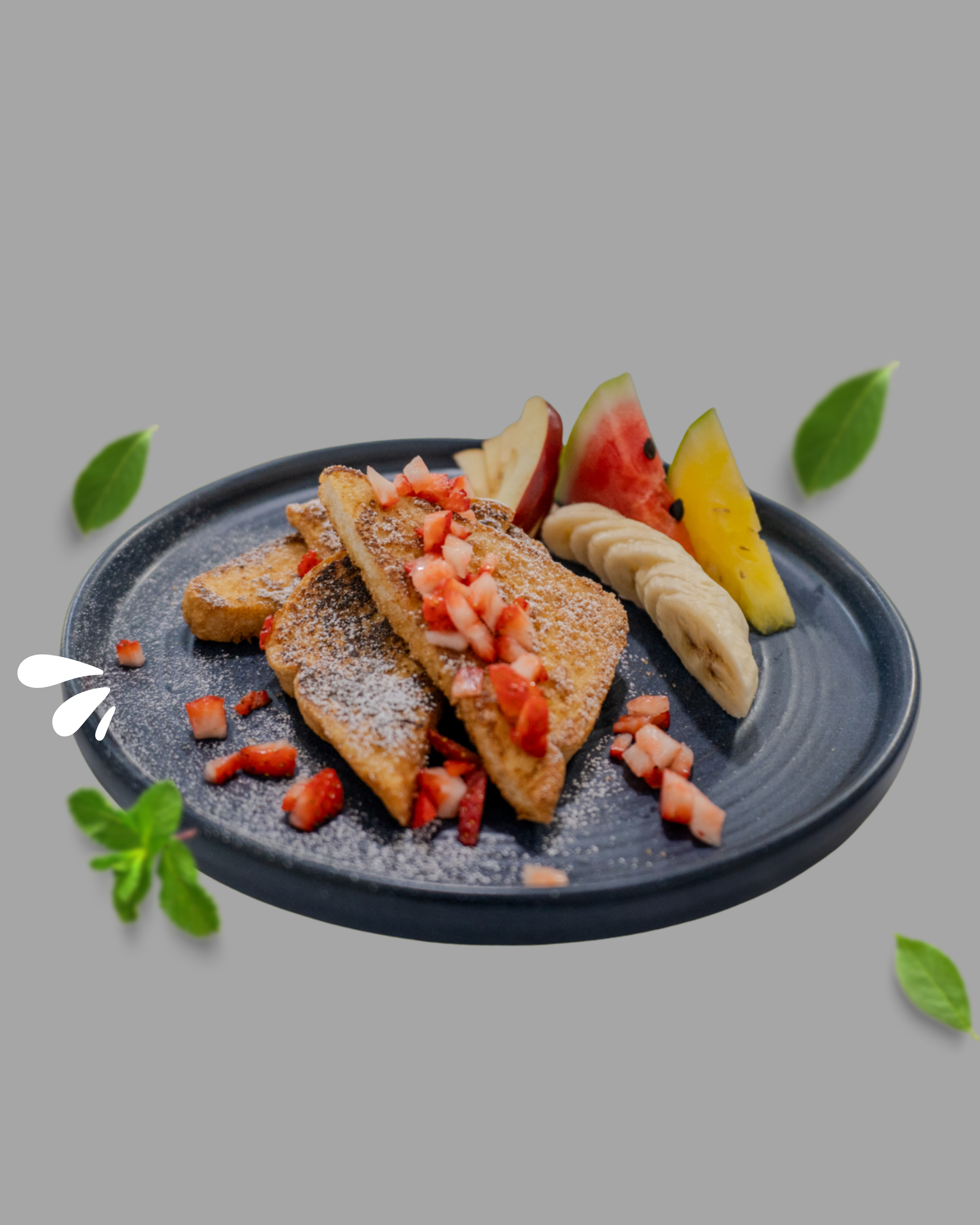 Tostadas con fresas, plátanos y sandía en plato negro, decorado con hojas verdes.