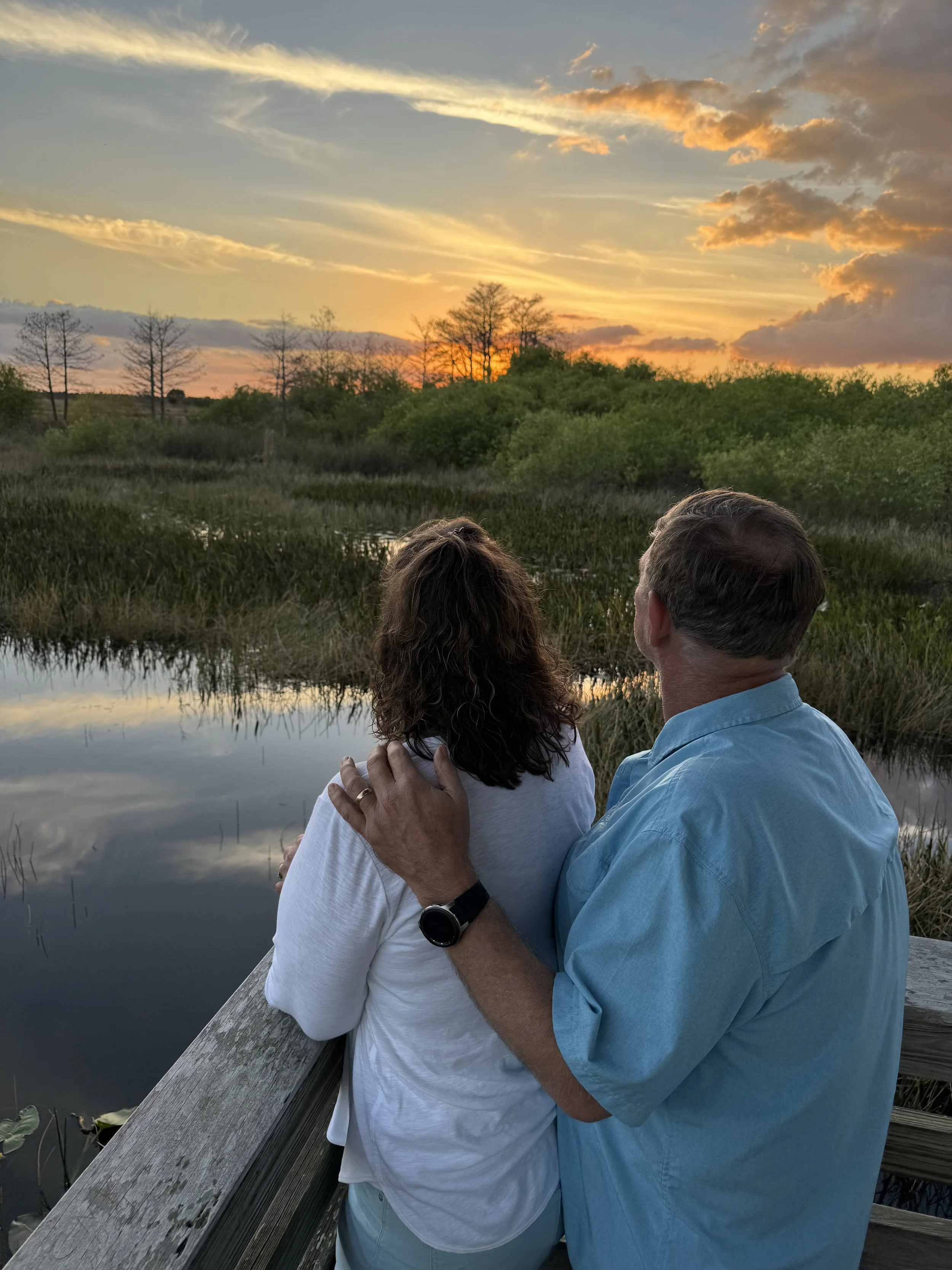 A couple looking at a sunset over a bog