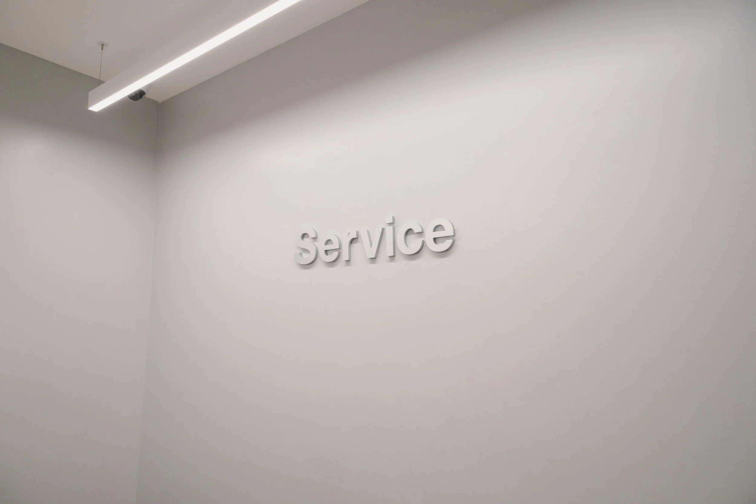 White wall with the word 'service' in 3D letters mounted on it.