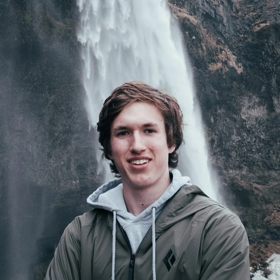 Gus De Vink smiling in front of a large waterfall.