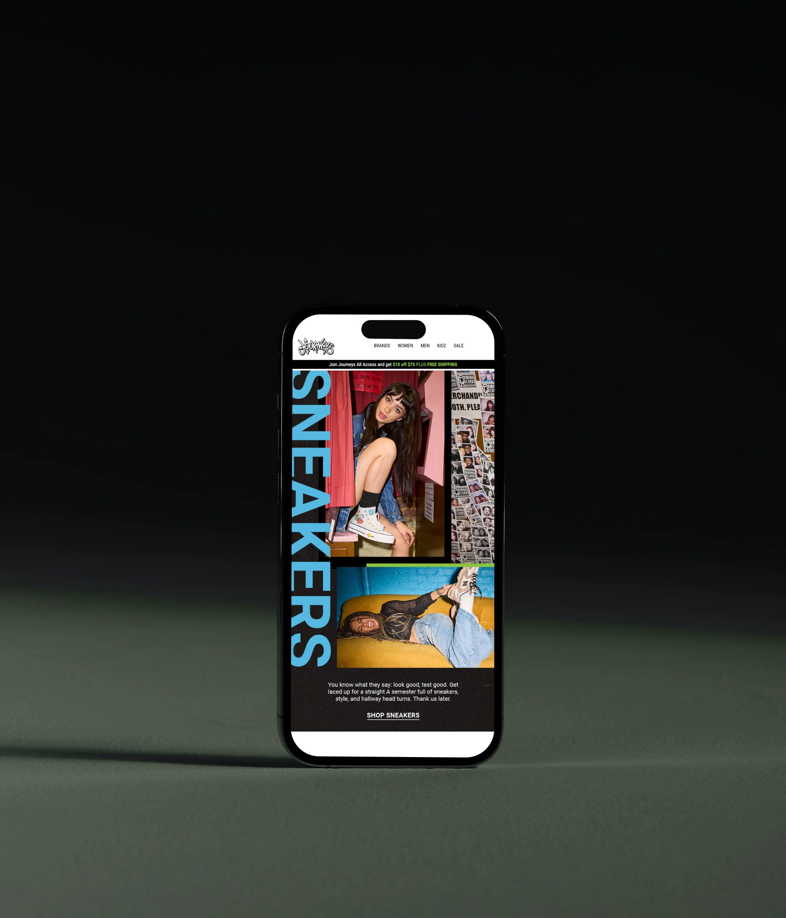 Smartphone on a dark surface displaying a website with models wearing sneakers and a sale promotion.