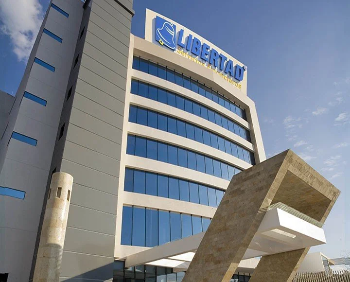 Edificio moderno con cartel que dice 'Libertad' en la parte superior y una estructura angular de piedra en la entrada.