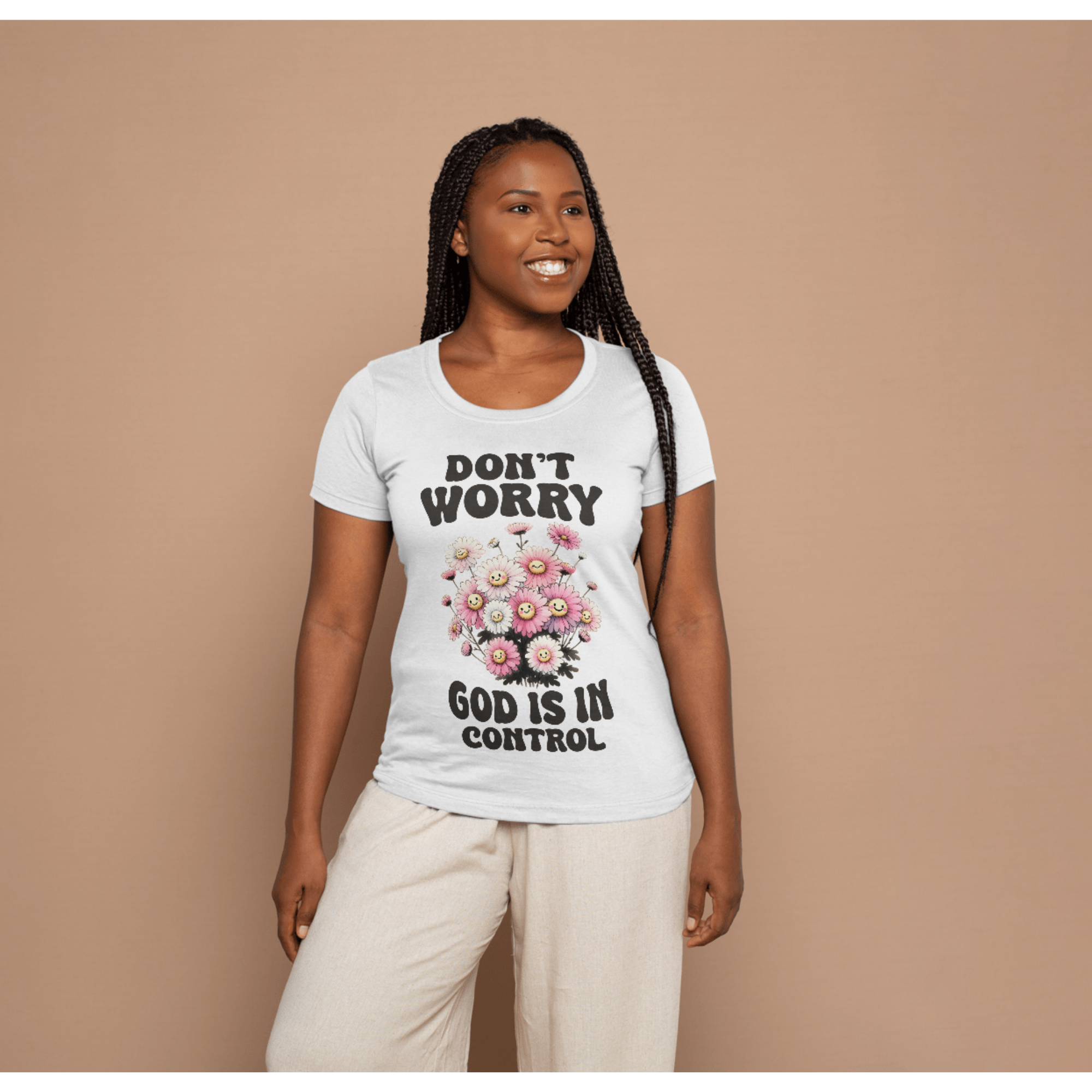 Woman wearing a white t-shirt with a floral graphic and text that reads 'Don't Worry God Is In Control'
