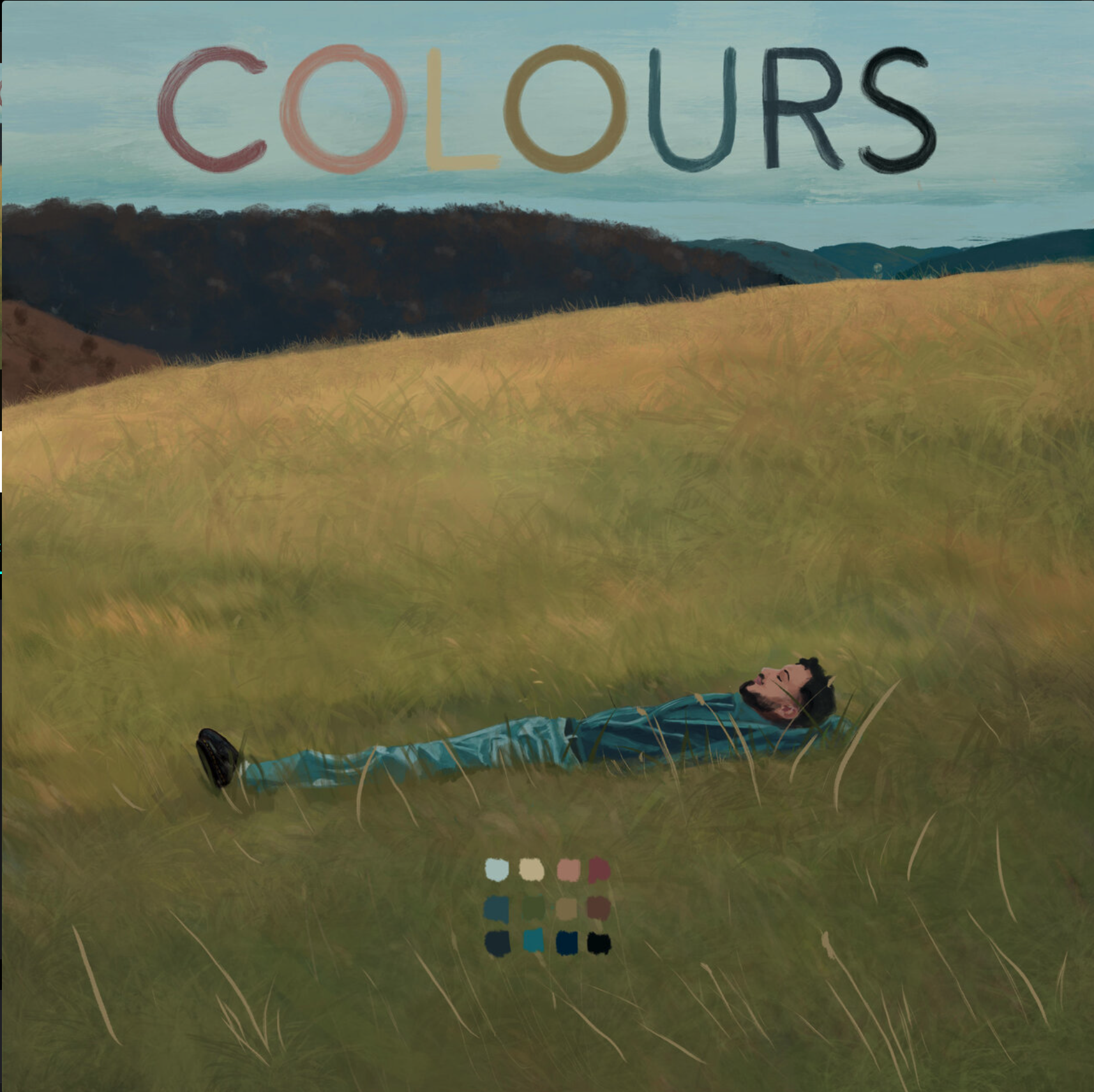 A man with a beard, wearing a blue jacket and jeans, lying on his back in a grassy field, looking up at the sky with the word 'COLOURS' displayed in large, colorful letters above him. Zuhair