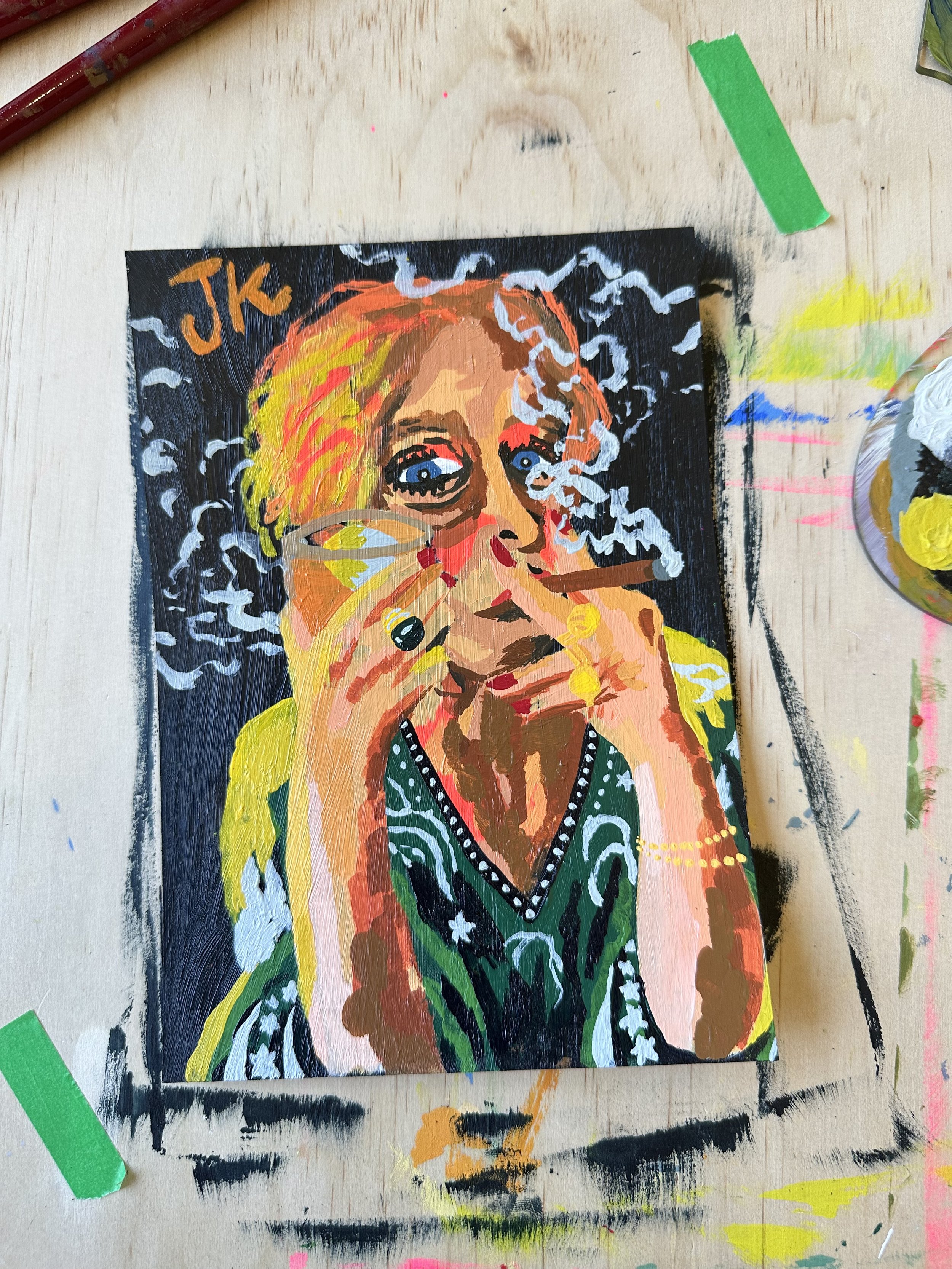 Photo of a painted artwork featuring a smoking figure and the letters 'JK'.