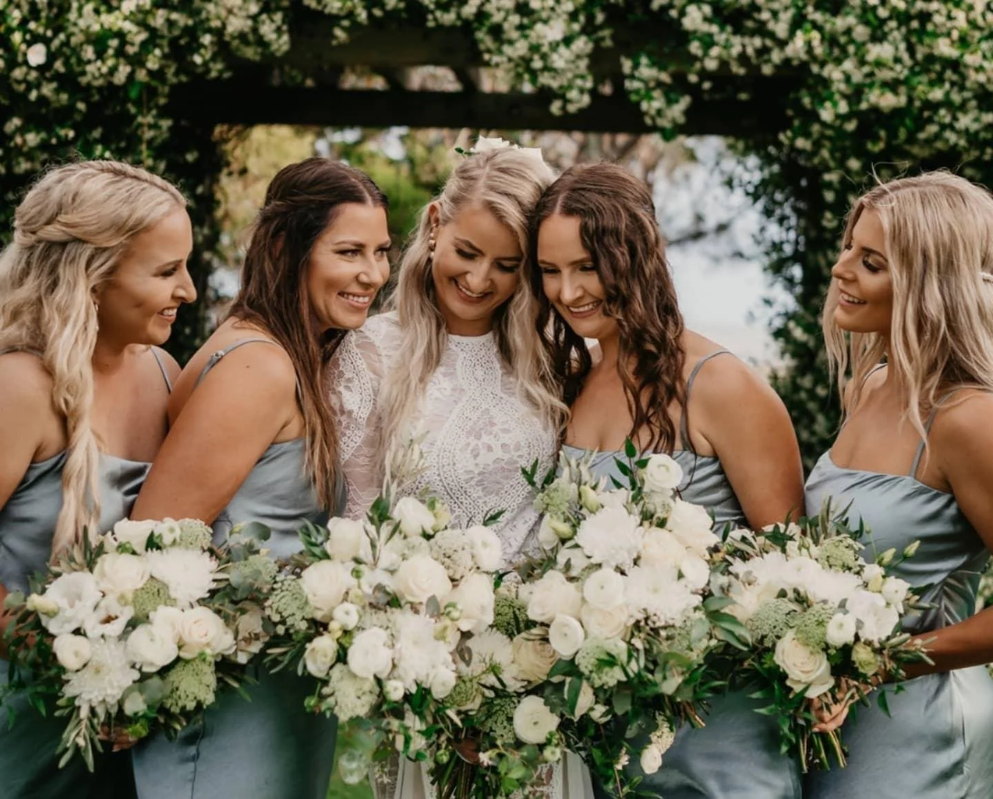 Bride and bridesmaids holding bouquets at a wedding outdoors