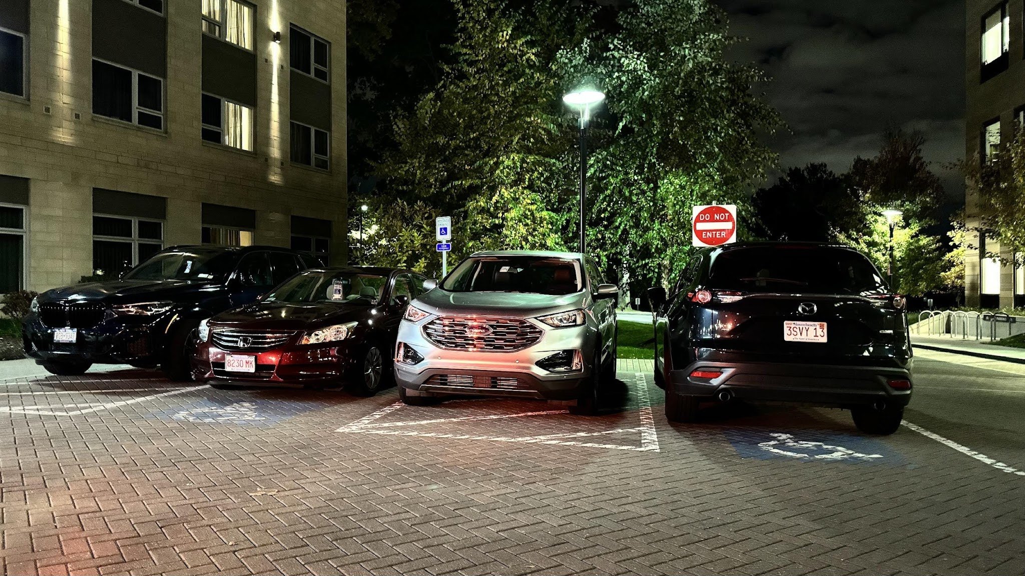 Parking lot at night with cars blocking accessible spaces