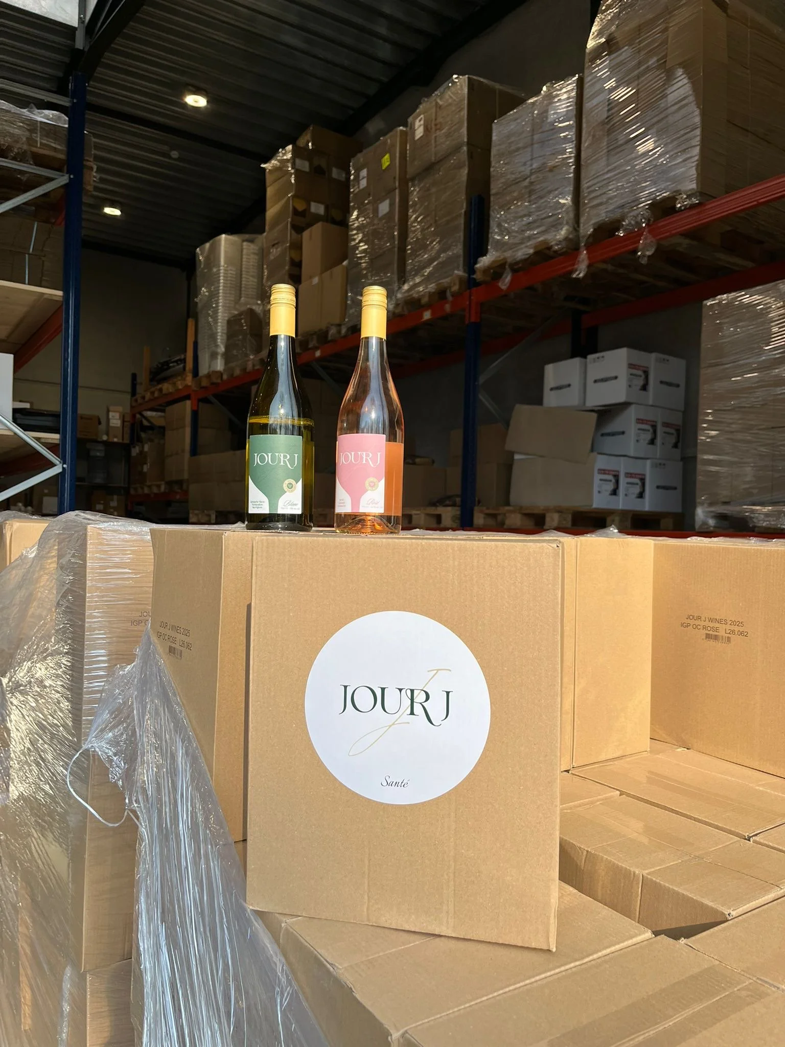 Wine bottles on top of cardboard boxes in a warehouse.