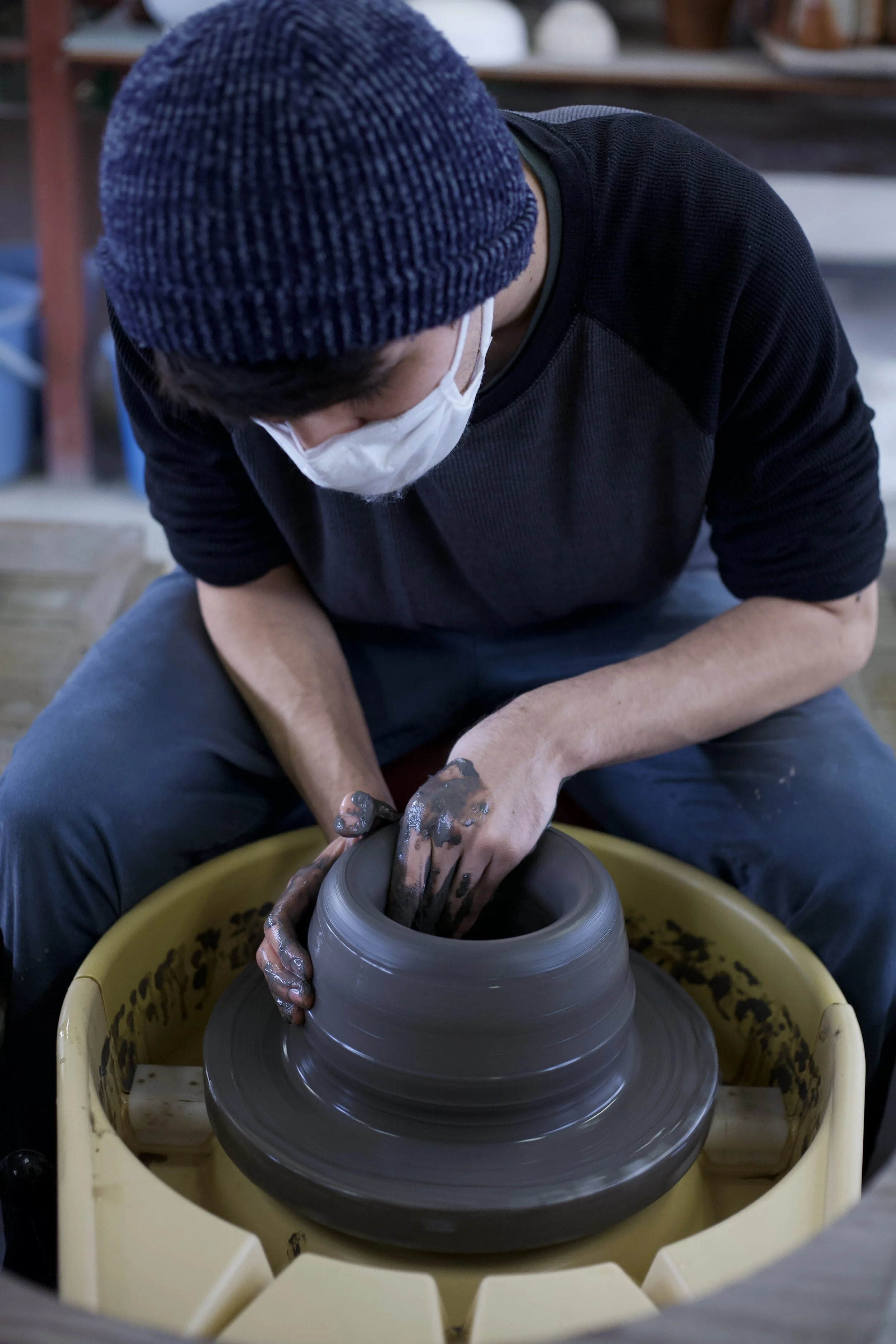 Young Japanese craftsman on a pottery wheel.