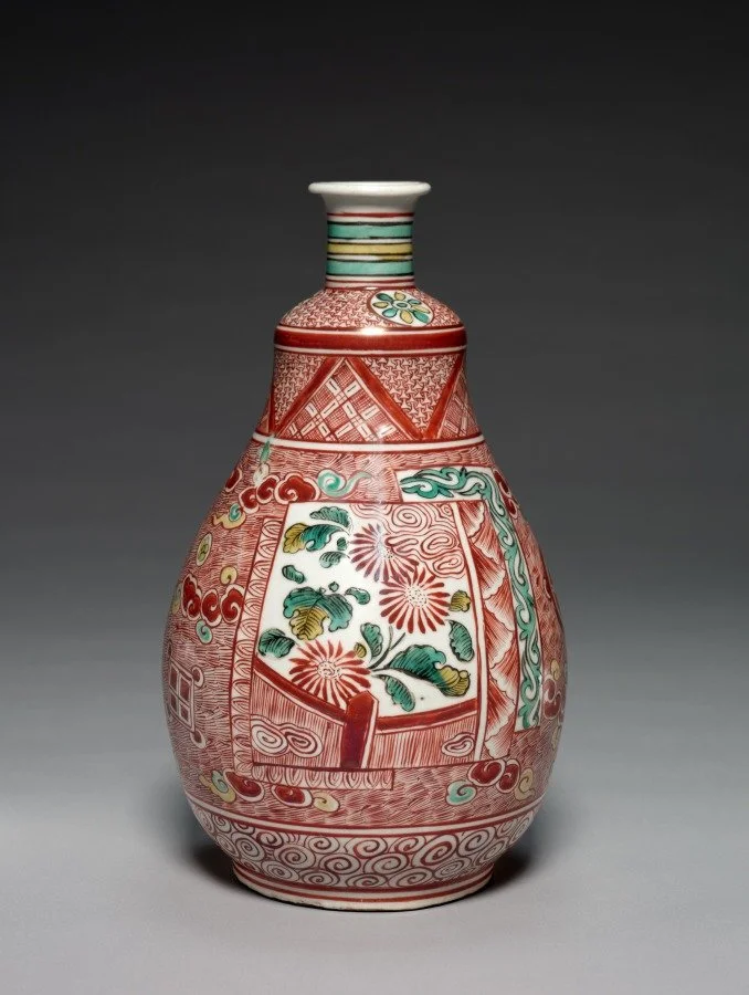 Decorative Edo Period ceramic vase with red, green, and white floral and geometric patterns on a porcelain vessel.