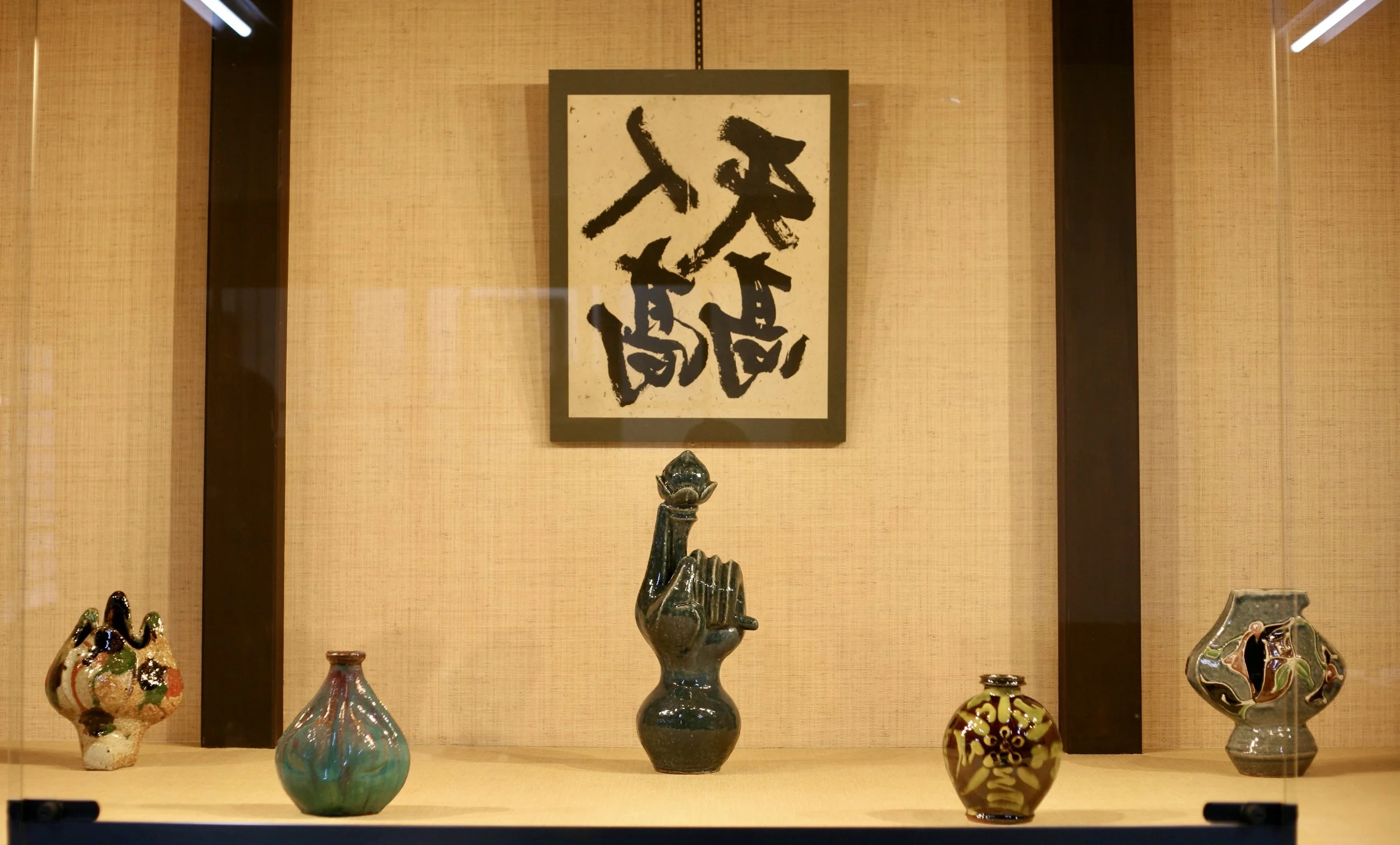 Display of five colorful pottery vases by Kawai Kanjiro.
