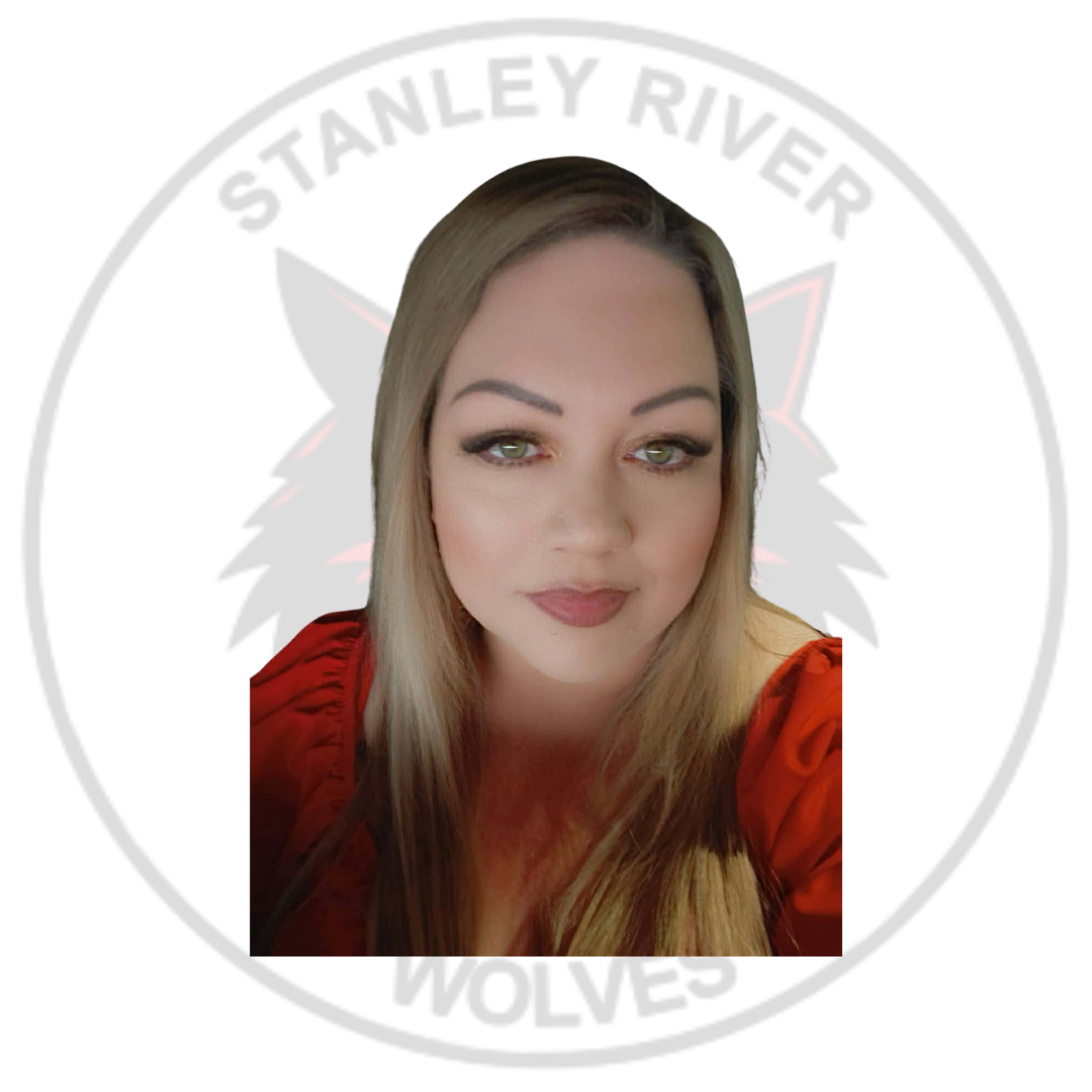 A woman with long blonde hair, wearing a red top, in front of a sticker featuring a black and red wolf and the text 'Stanley River Wolves' curved around the top and bottom of the circle.