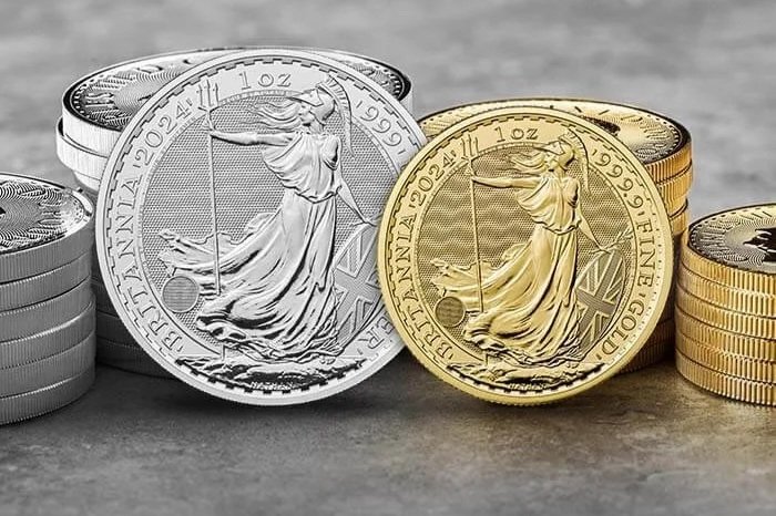 Close-up of silver and gold American Eagle coins stacked and scattered on a surface.