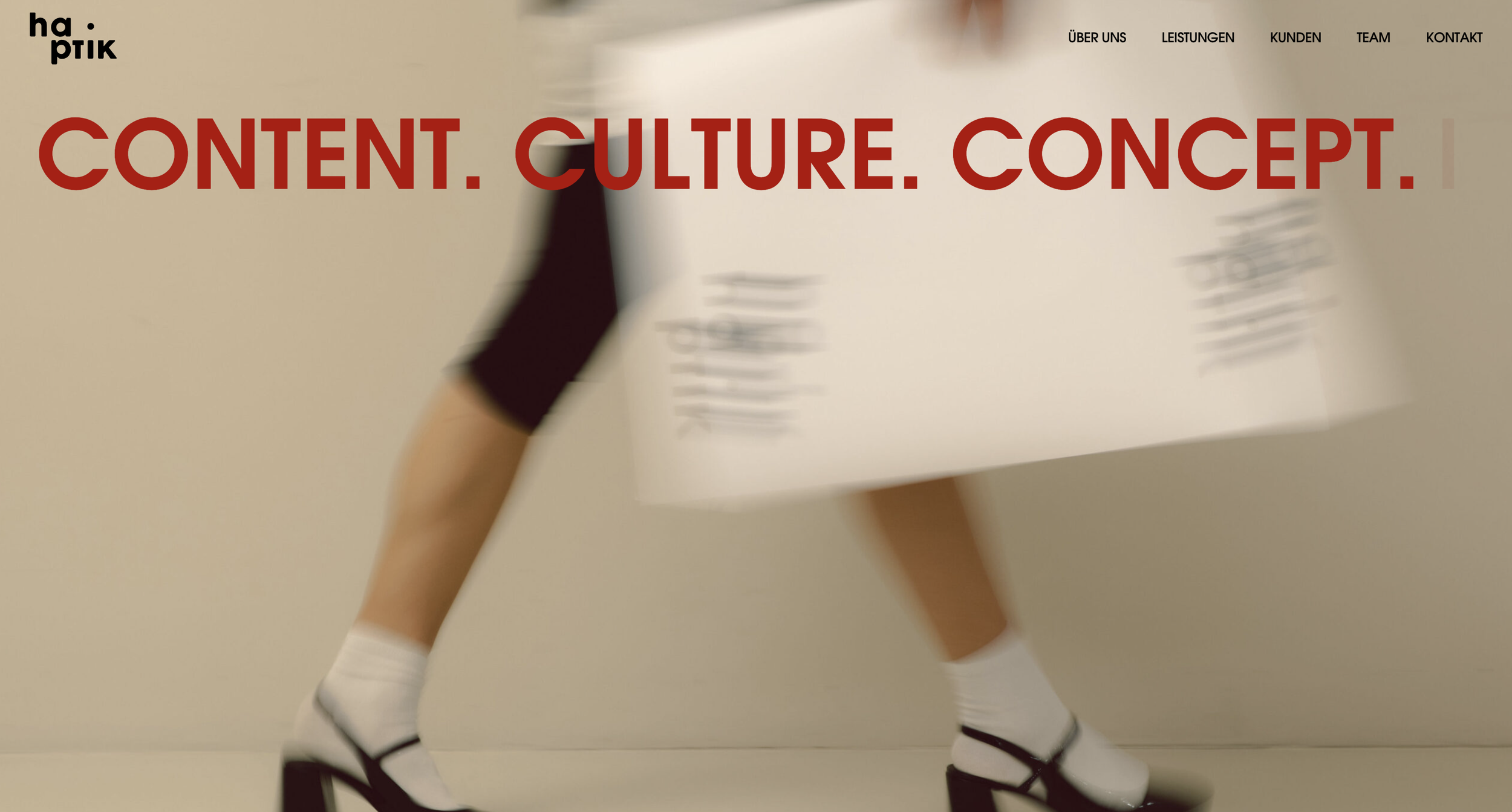 Hapitk Agentur Köln Bielefeld. Website homepage with large red text 'CONTENT. CULTURE. CONCEPT.' over a blurred image of person walking in high heels carrying a large piece of paper.