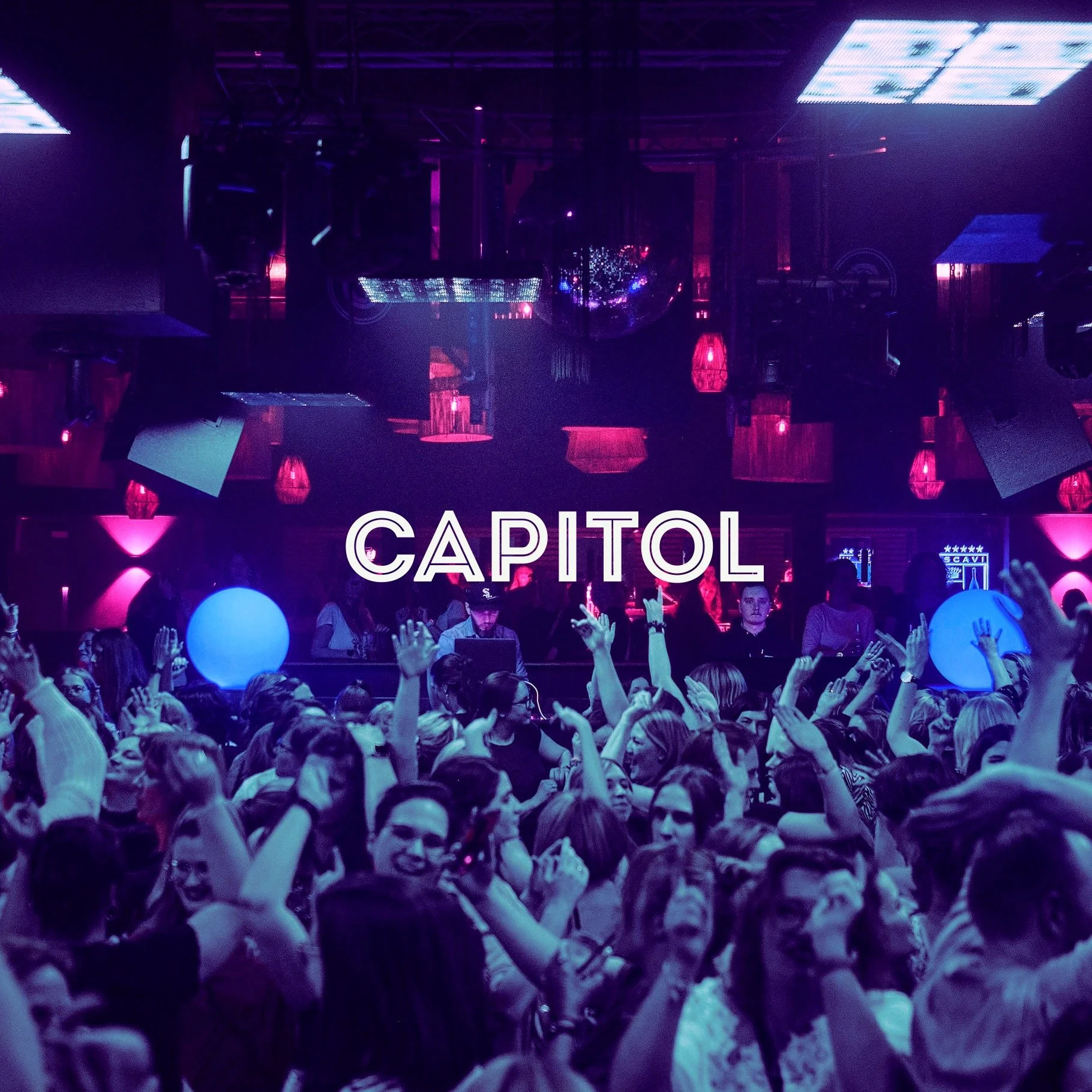 Capitol Paderborn Club Events . Crowd dancing and celebrating at Capitol nightclub with purple and pink lighting, disco balls, and large glowing balloons.