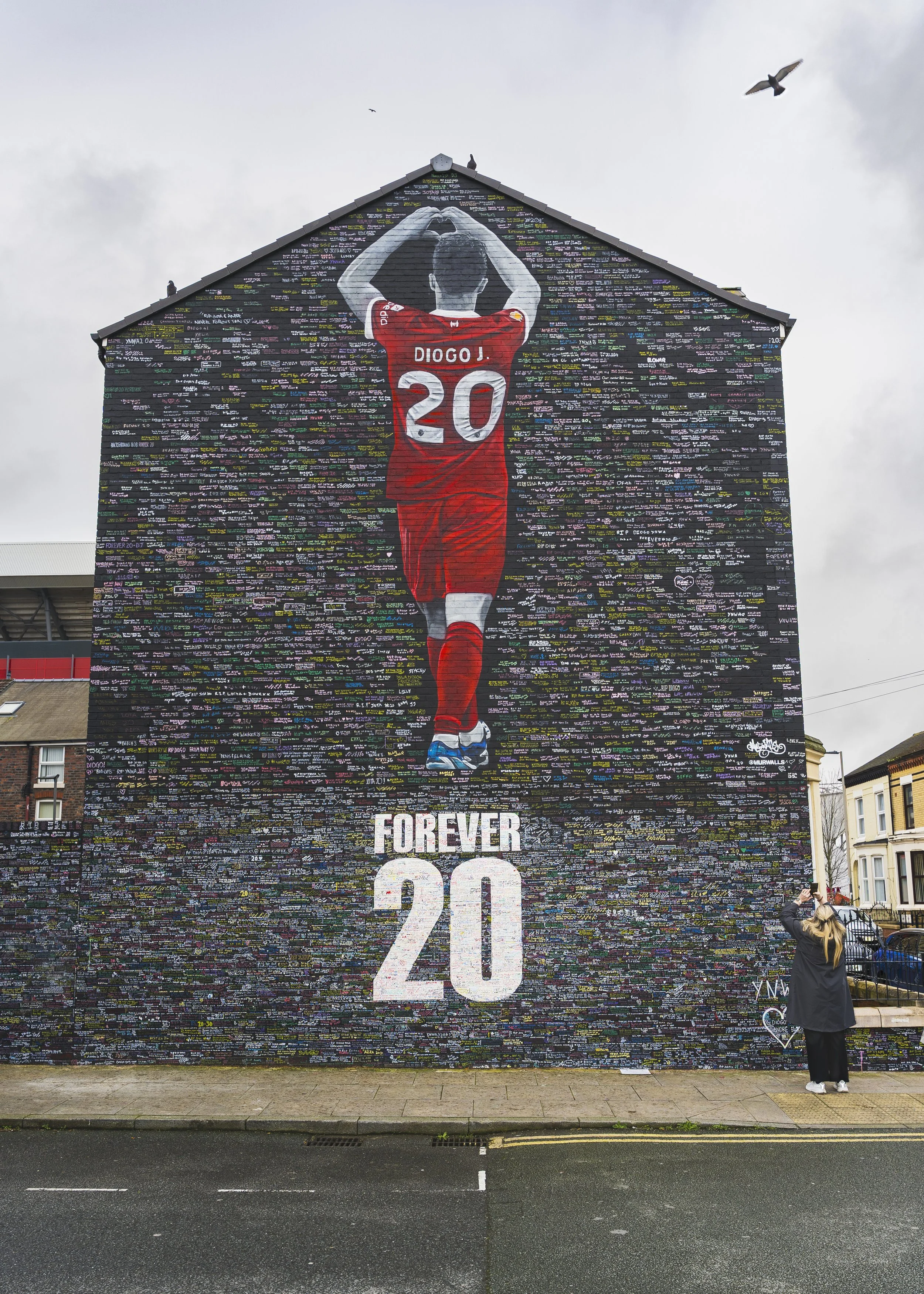 Guðny Stefanía Stefánsdóttir, from Iceland, taking a picture of her sons writing on the Diogo Jota mural outside of Anfield stadium.