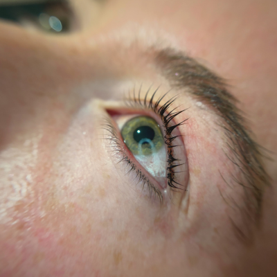 Close-up of a person's eye with long eyelashes and light skin.