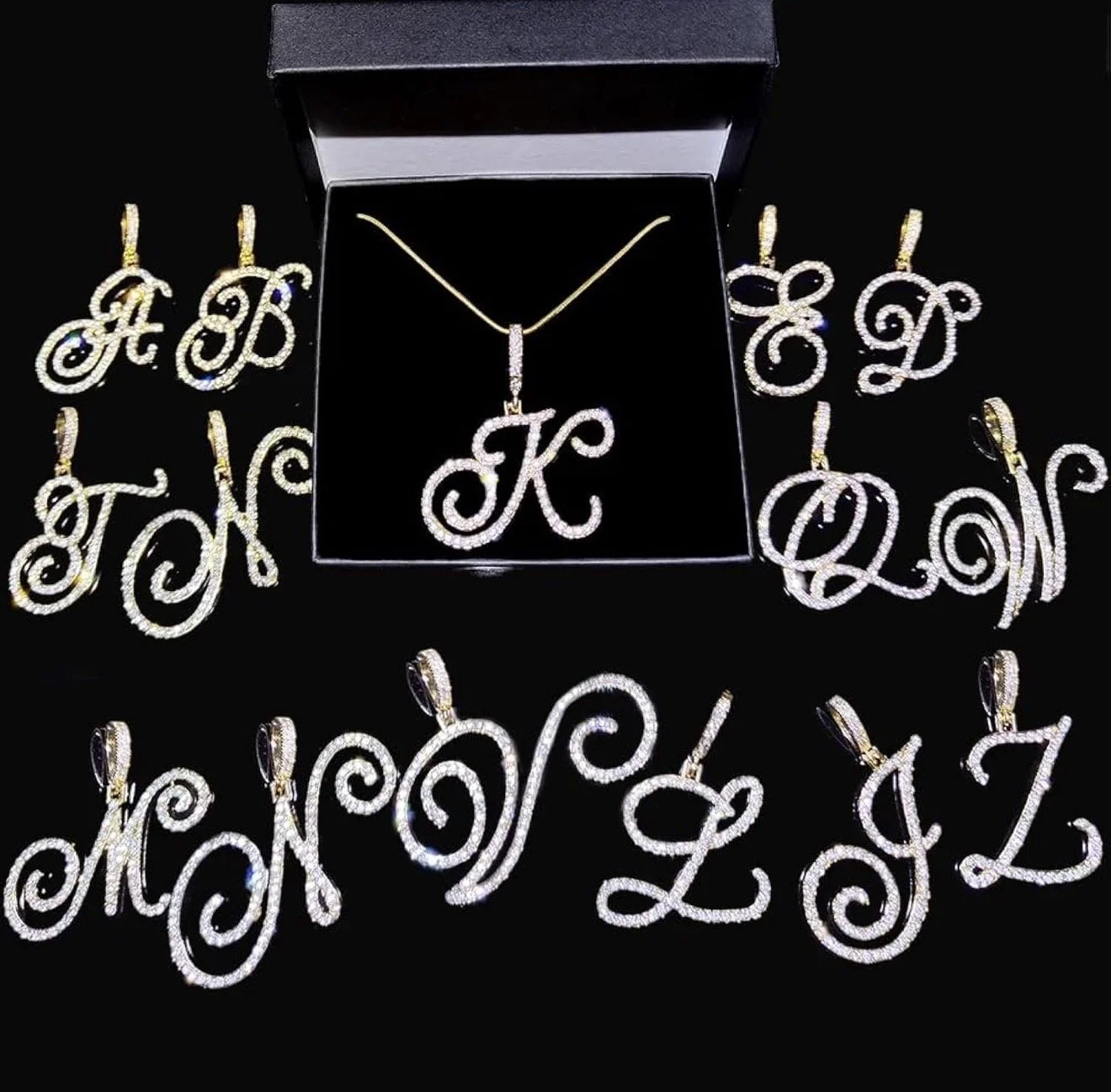 Set of gold and silver jewelry with letter initials coated in diamonds, including necklaces and earrings, displayed on a black background.