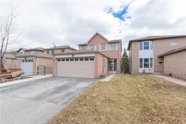Two-story houses with garages on a suburban street, cloudy sky, and a grassy front yard.