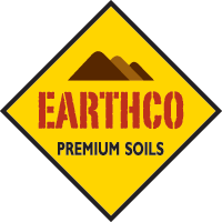 A yellow diamond-shaped sign with a black border, featuring a mountain graphic and the words 'EARTHCO PREMIUM SOILS' in red and black text.