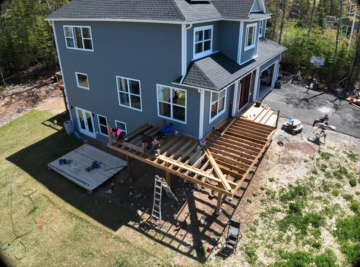 An aerial view of a house under construction showing workers building a wooden deck.