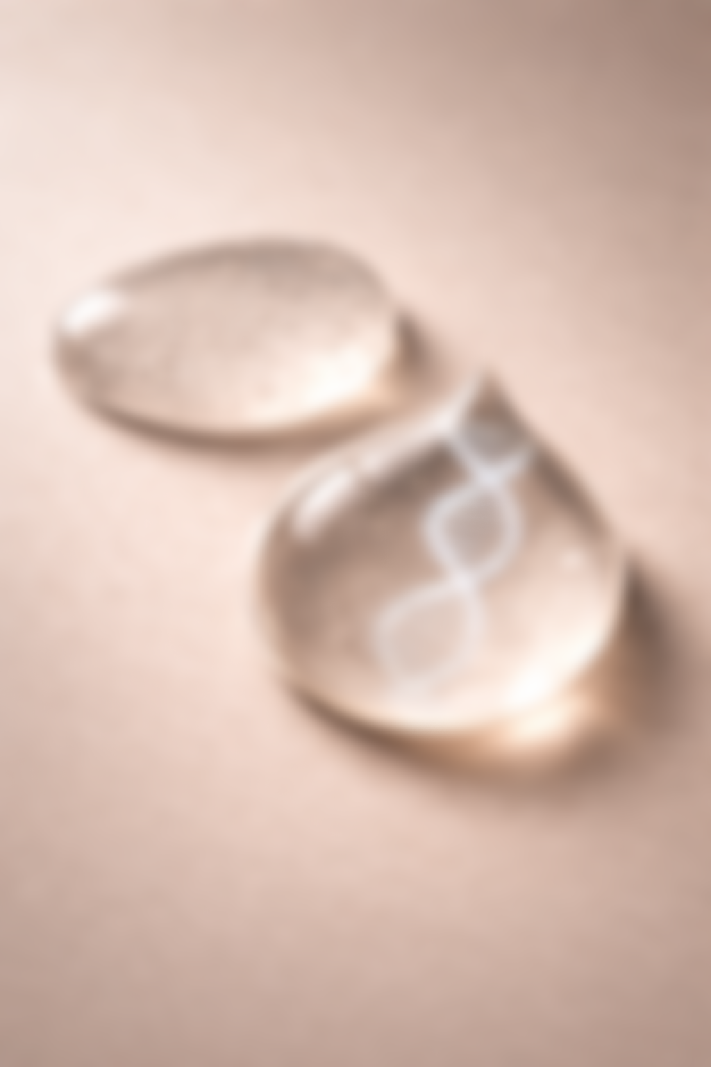 Close-up of two silver ring-shaped objects on a light-colored surface, one with engraved circles.