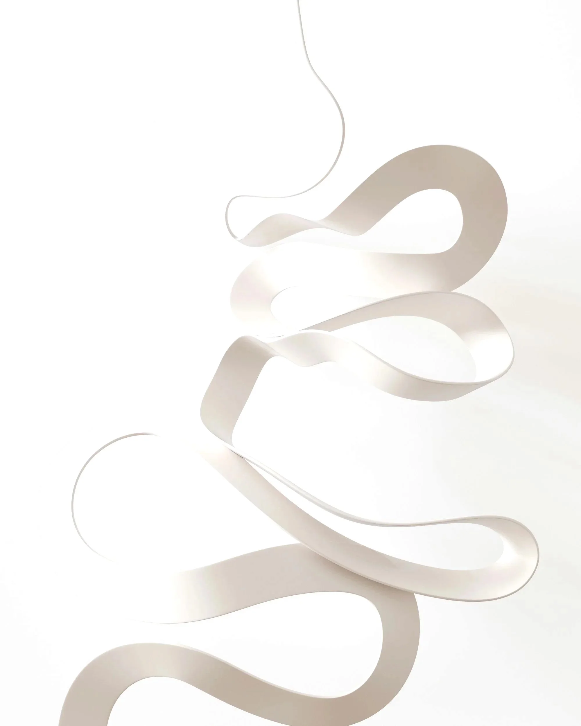 Abstract white ribbon sculpture with flowing curves on a white background.
