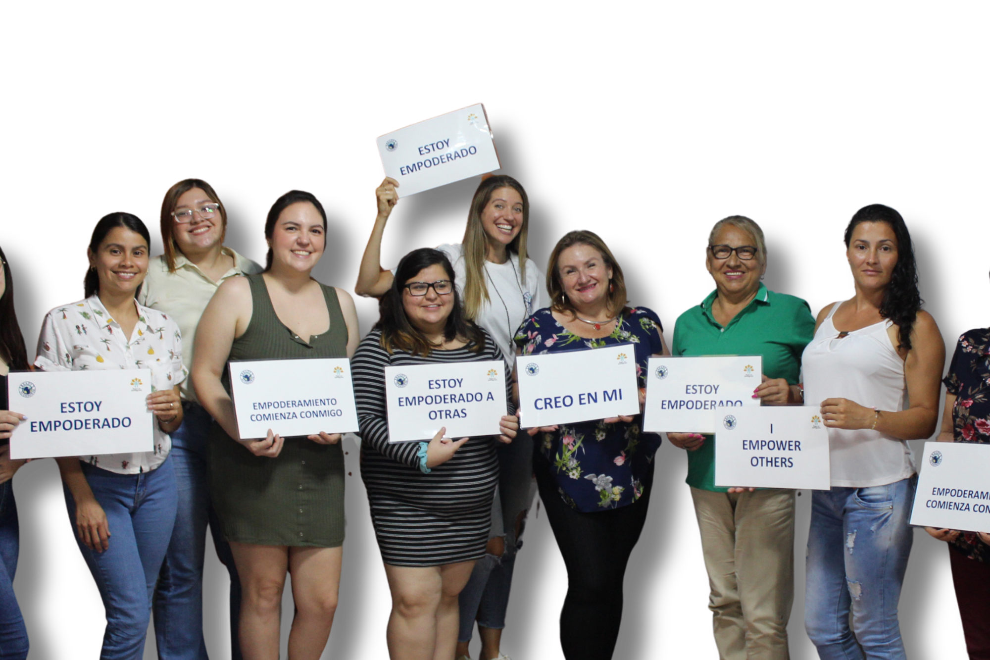 Group of diverse women smiling and holding signs that say positive messages about empowerment, standing against a black background.