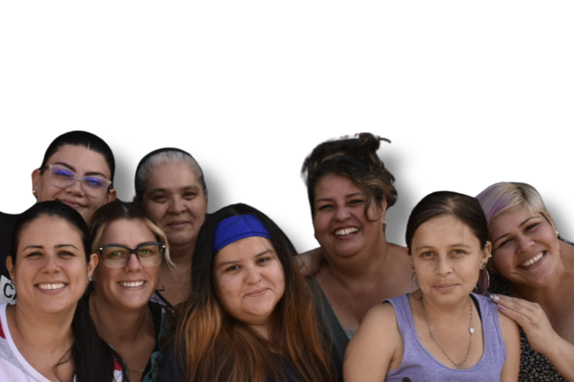 Group of eight smiling women standing close together against a black background.