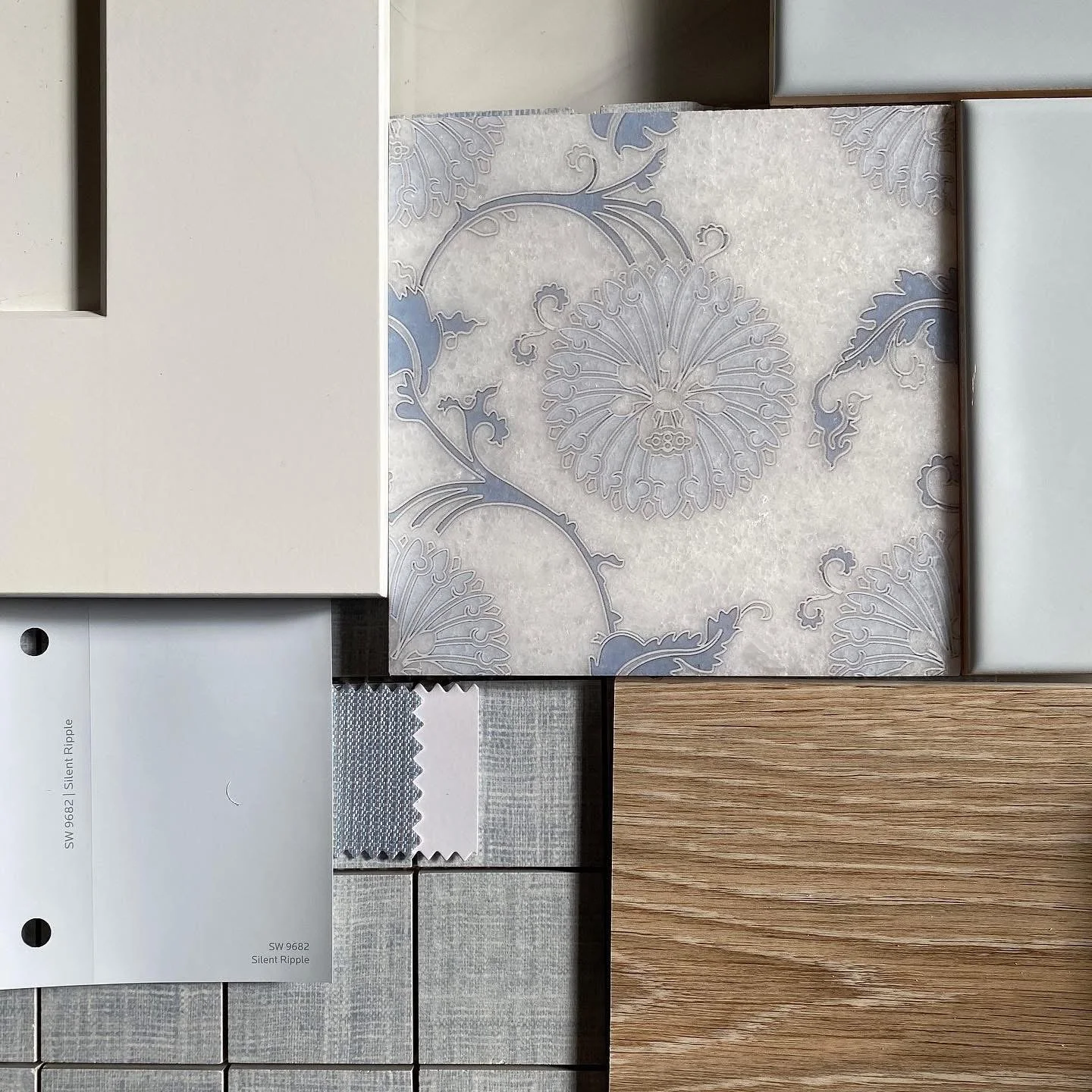 A collection of wall and surface materials, including patterned wallpaper, fabric swatches, wood, and assorted tiles.